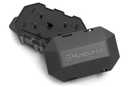 The Husqvarna Automower® Area Switch, enclosed in a gray plastic rectangular casing with a detachable cover, features the Husqvarna logo on top and includes various mounting points and connectors for electronic components. This shell is integral to the Husqvarna Automower, specifically designed to manage the boundary wire and Area Switch configurations.