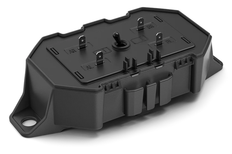 The Husqvarna Automower® Area Switch, enclosed in a gray plastic rectangular casing with a detachable cover, features the Husqvarna logo on top and includes various mounting points and connectors for electronic components. This shell is integral to the Husqvarna Automower, specifically designed to manage the boundary wire and Area Switch configurations.