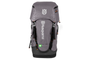 A versatile gray Husqvarna Gear backpack 70L with multiple pockets and orange accents, prominently displaying the Husqvarna logo on the front. A small green first aid symbol is near the bottom, making it ideal for climbing gear. The bag is set against a black background.