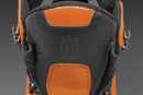 A pair of sturdy, orange and black Husqvarna Protective Leather Boots Technical Light. The boots feature thick rubber soles with deep treads for good traction, metal eyelets, black laces, and reinforced toe caps. One boot stands upright while the other is tilted on its side, reminiscent of rugged motorbike parts.