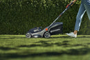 Image of a Husqvarna Aspire™ L34 Lawn Mower (Kit) with an 18V battery. The black mower, accented in orange, features a sleek design and a grass collection bag at the back. With the POWER FOR ALL battery system, its handlebar is adjustable and foldable for easy storage.