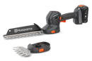 The Husqvarna Aspire™ Shrub Shear 18V (Skin) is a sleek, modern black and orange battery-operated hedge trimmer with an 18V POWER FOR ALL ALLIANCE system. It includes a detachable blade and interchangeable Shrub Shear attachment, displayed on a plain white background.