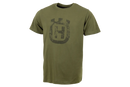 The Husqvarna Xplorer T-Shirt Short Sleeve - Tree Ring Crown is an olive-green, short-sleeve sustainable t-shirt crafted from organic cotton and recycled polyester. It showcases a distressed black graphic design with a stylized shield and a capital "H" in the center on the front. The shirt features a crew neck and has an unwrinkled appearance.