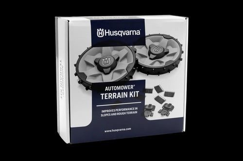 The Husqvarna Automower® Rough Terrain Kit by Husqvarna is displayed, featuring two rugged, circular robotic mower wheels with black and white treads. These treaded wheels have thick patterns suitable for rough terrain, providing excellent traction with accents in orange and gray, accompanied by a set of five small, black bristle brushes.