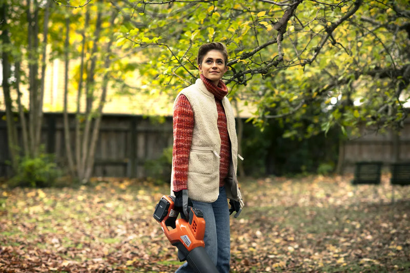 The Husqvarna 230iB Leaf Blower skin, featuring a brushless motor for enhanced efficiency, showcases a sleek orange design with black and gray accents. The "Husqvarna" name is proudly displayed on the tube, and its ergonomic handle ensures comfortable operation.