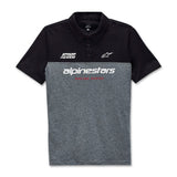 The Alpinestars Paddock Polo Black/Charcoal by Crown Kiwi Enterprises Limited features a stylish black top and gray bottom. It is accented with the "Alpinestars" branding in white and "Racing Ahead" in red, along with a small HD logo above the text for added flair. With its collar and white buttons, this polo is ideal for racing enthusiasts wanting to make a statement.