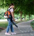 The Husqvarna Toy Backpack Bubble Blower Bundle by Husqvarna Toys features an attractive orange and grey design. It includes adjustable shoulder straps, a padded back, and a handheld blower nozzle. The blower stands upright like an MX motorbike, highlighting its compact yet durable build for outdoor fun.