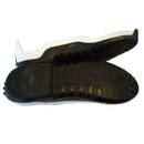 The Alpinestars Tech-3/Tech-2 black and white sports shoe soles by Crown Kiwi Enterprises Limited are displayed one over the other, showcasing detailed tread patterns and cleats for optimized traction.
