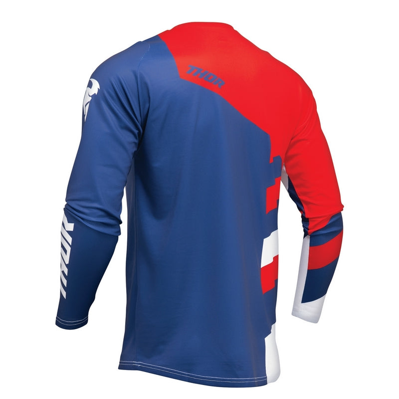 The THOR SECTOR CHECKER JERSEY YOUTH NV/RD by THOR MX is a long-sleeved motocross jersey made from moisture-wicking fabric. It displays striking red, blue, and white geometric patterns as part of the Sector Collection. Featuring prominent "THOR" branding on the chest and "SECTOR" on the lower side, it's perfect racewear for intense rides.