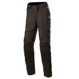 The Alpinestars Stella Gravity Drystar Pants, offered by Crown Kiwi Enterprises Limited, are shown on a white background. This pair of black motorcycle pants boasts CE certification, waterproof capabilities, reinforced knee areas, and multiple zippered pockets for enhanced durability and protection.