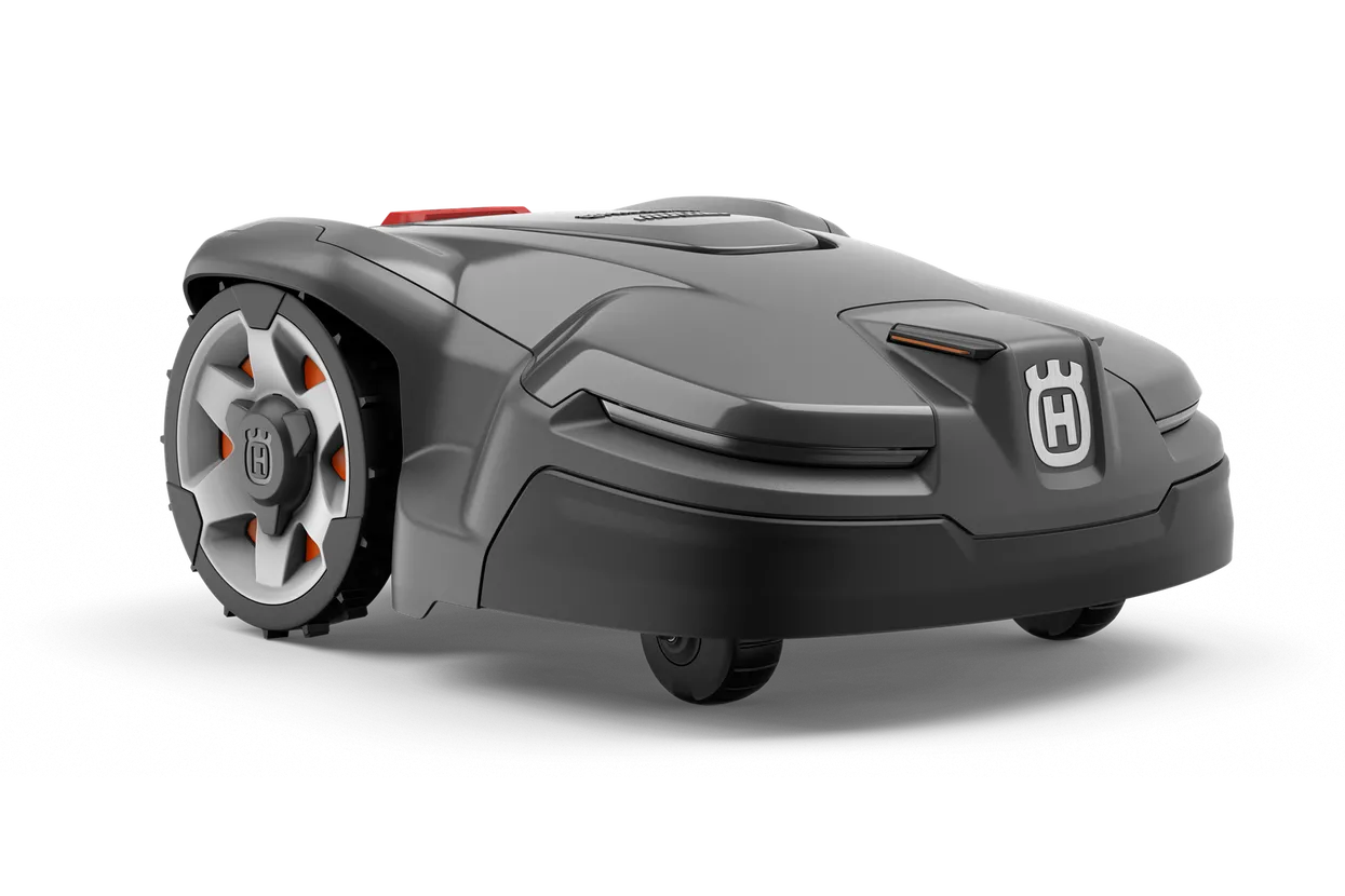 A sleek, modern, gray Husqvarna AM405X Automower with large wheels and an H emblem on the front. Its compact, angular design is perfect for outdoor gardens and is engineered for autonomous grass cutting.