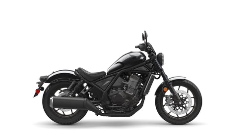 A black Honda Rebel CMX1100 DCT motorcycle is shown in profile against a white background. The cruiser class bike features a low seat, wide handlebars, and a robust engine with automatic transmission. It boasts a modern, minimalist design with sleek lines and a matte finish, including spoked wheels and disc brakes.