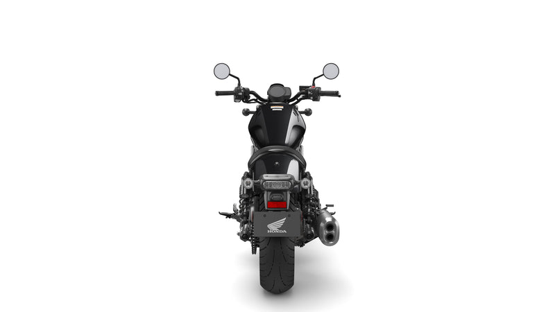 A black Honda Rebel CMX1100 DCT motorcycle is shown in profile against a white background. The cruiser class bike features a low seat, wide handlebars, and a robust engine with automatic transmission. It boasts a modern, minimalist design with sleek lines and a matte finish, including spoked wheels and disc brakes.