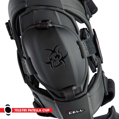 A pair of black KNEE BRACES ASTERISK JUNIOR CELL FOR DIRTBIKE RIDERS with adjustable straps and padding for support and protection. Each brace features a skeletal design logo on the front, part of the ASTERISK Junior Cell knee protection system.