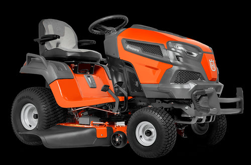 A Husqvarna TS242TXD Ride-On Mower is shown in bright orange, featuring a comfortable gray seat with armrests, large textured tires, and a robust ClearCut™ deck underneath. The side discharge tractor boasts a modern design with the prominent Husqvarna logo on its front.