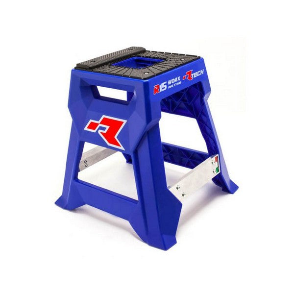 The RTECH R15 Works Cross Bike Stand Launch Edition Blue is a blue and black step stool made of durable plastic with a rectangular shape and sturdy injection-molded construction. It prominently features the red "R" logo along with additional branding text. The stool includes non-slip surfaces on the steps, offers stable support, and boasts a high maximum load capacity.