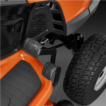 A Husqvarna TS242TXD Ride-On Mower is shown in bright orange, featuring a comfortable gray seat with armrests, large textured tires, and a robust ClearCut™ deck underneath. The side discharge tractor boasts a modern design with the prominent Husqvarna logo on its front.