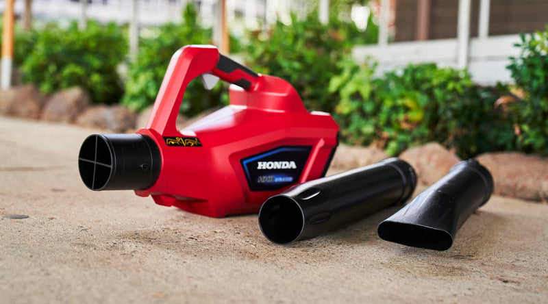 The Honda HHB36 Battery Blower Kit from Honda Power Equipment is a red and black, 36V battery-powered leaf blower with a long nozzle and detachable battery. It features a powerful electric motor, with a harness and straps to be worn around the waist for easier handling, complemented by a handle on top for convenience.