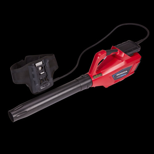 The Honda HHB36 Battery Blower Kit from Honda Power Equipment is a red and black, 36V battery-powered leaf blower with a long nozzle and detachable battery. It features a powerful electric motor, with a harness and straps to be worn around the waist for easier handling, complemented by a handle on top for convenience.