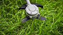 A red and silver gasoline-powered string trimmer/brush cutter with a long straight shaft, bicycle-style handles, and a black cutting head at the end. Experience similar performance to the Honda HHT36 Battery Brushcutter Kit from Honda Power Equipment for efficient yard maintenance.