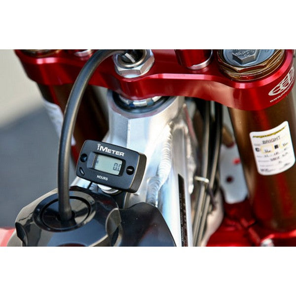 A corrosion-resistant aluminum bracket with a central circular hole and two smaller holes on either side, accompanied by two small screws placed below, against a white background, is used to mount the HARDLINE HOUR METER MOUNT HARDLINE MOUNTS YOUR HARDLINE HOUR METER INSTRUMENT STYLE.