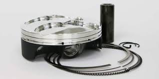 Displayed on a clean white background, the PISTON KIT CP CARRILLO KAWASAKI KX250F 2020 78MM from CP CARRILLO includes a metal piston with rings, a cylindrical pin, and a circlip. The kit showcases a segmented design with its components neatly arranged to highlight the key parts of a racing engine's internal combustion piston assembly.