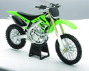 A green MODEL DIRT BIKE KAWASAKI KX450F 1:12 SCALE BY NEW RAY is displayed on a black stand in a well-lit setting. The bike, featuring a black seat and silver frame, has knobby tires designed for off-road terrain and showcases intricate mechanical details.