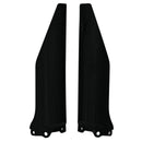 A pair of RTECH black plastic fork protectors, designed for Kawasaki KX125 and KX250 (04-06) as well as Suzuki RMZ250 (04-06) models, stand upright. Each protector is long and slender, crafted to shield the front suspension forks of a dirt bike. The bottom section features mounting holes for easy attachment, making them perfect for Suzuki RMZ250 from 2004 to 2006.