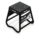 The MATRIX Mini A2 Stand Black is a black and white metal motorcycle stand made from aircraft quality tubing. It has a square top with a textured pattern and "Matrix" branding on the sides, featuring an anti-rock design and a sturdy, minimalist frame.
