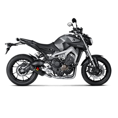 The Akrapovic Full System for Yamaha MT09/XSR900 by AKRAPOVIC is a racing exhaust with a sleek metallic finish, featuring multiple curved pipes leading to a black carbon fiber muffler adorned with a red and yellow logo.