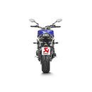 The Akrapovic Full System for Yamaha MT09/XSR900 by AKRAPOVIC is a racing exhaust with a sleek metallic finish, featuring multiple curved pipes leading to a black carbon fiber muffler adorned with a red and yellow logo.