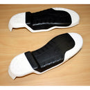 The Alpinestars Tech-7 Sole White/Black by Crown Kiwi Enterprises Limited, featuring sleek and bold protective inserts, rests on a wooden surface. These are designed for shoes or boots with textured grips and raised sections for enhanced support and durability.